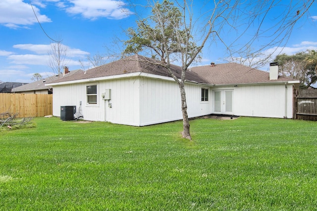 back of house with central AC and a yard