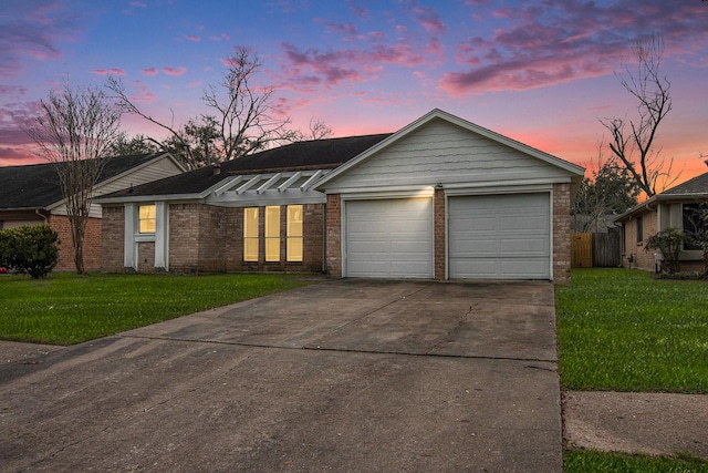 single story home featuring a garage and a yard