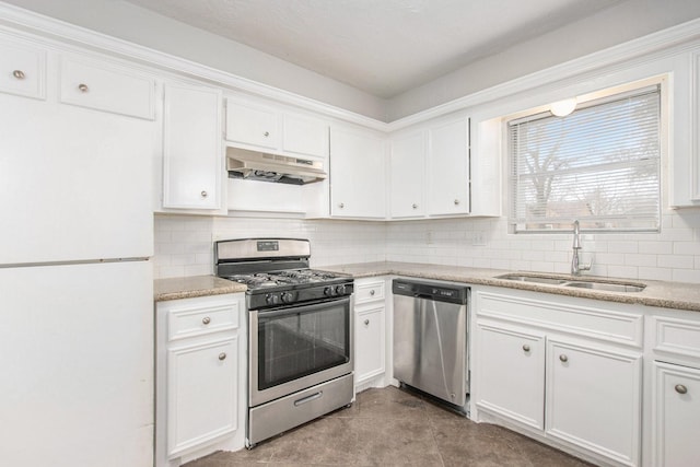 kitchen with appliances with stainless steel finishes, sink, decorative backsplash, and white cabinets