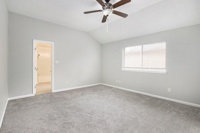 empty room with ceiling fan, carpet flooring, vaulted ceiling, and a textured ceiling