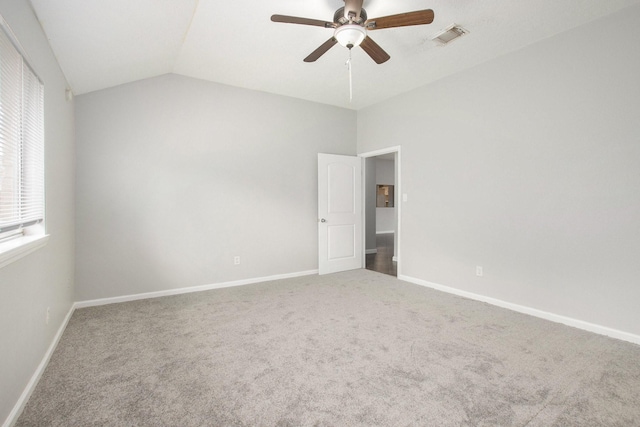 empty room with vaulted ceiling, carpet floors, and ceiling fan