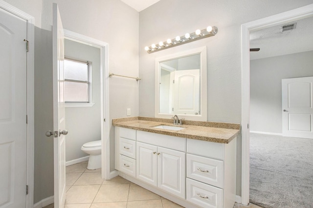 bathroom featuring vanity, tile patterned flooring, and toilet