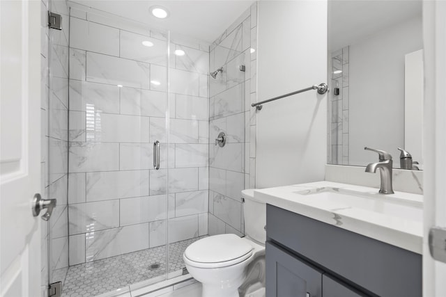 bathroom with a shower with door, vanity, and toilet