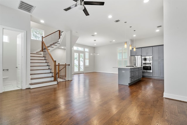 unfurnished living room featuring dark hardwood / wood-style floors, ceiling fan, and french doors