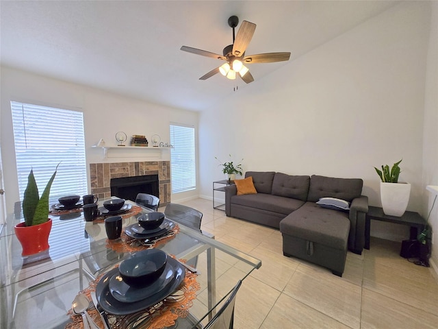 living room featuring light tile patterned floors, a fireplace, and ceiling fan