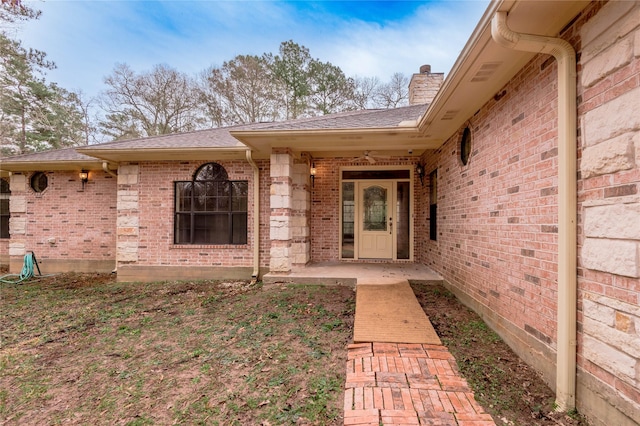 property entrance featuring brick siding and a chimney