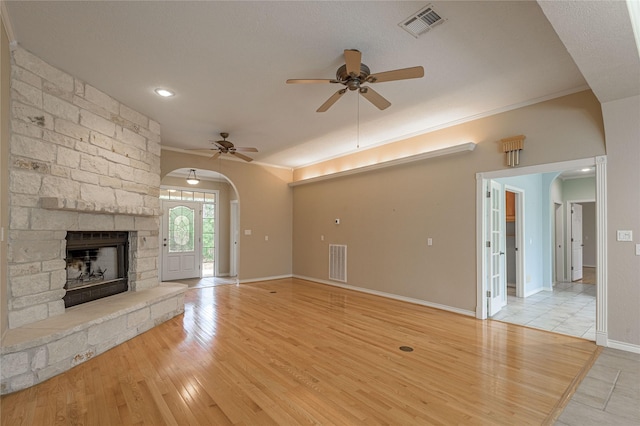 unfurnished living room featuring light wood finished floors, a fireplace, and visible vents