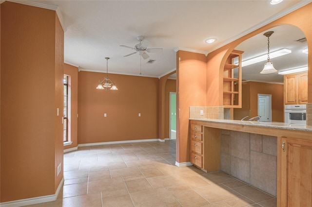 kitchen featuring ornamental molding, light countertops, a ceiling fan, and oven