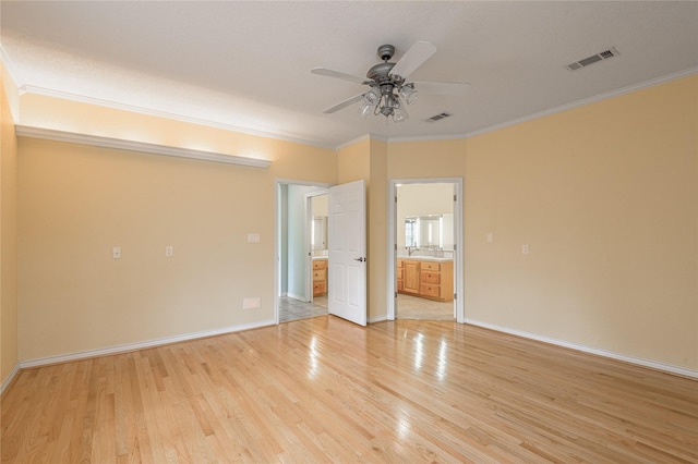 unfurnished room with visible vents, crown molding, and light wood-style flooring