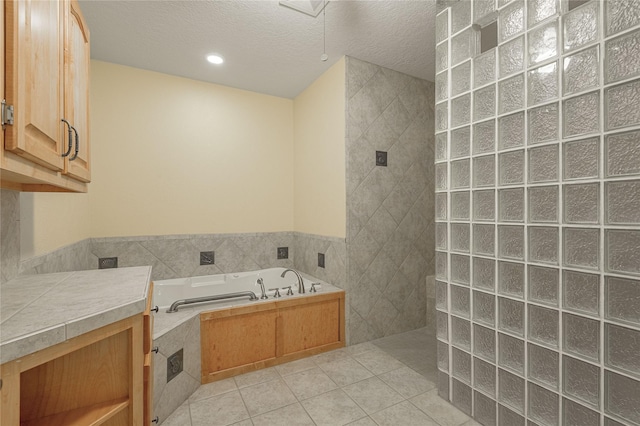 bathroom with a textured ceiling, tile patterned flooring, tile walls, a bath, and walk in shower