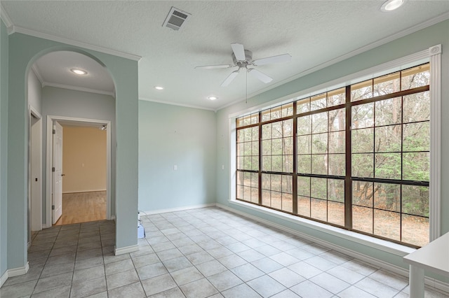 unfurnished room with ornamental molding, arched walkways, visible vents, and plenty of natural light