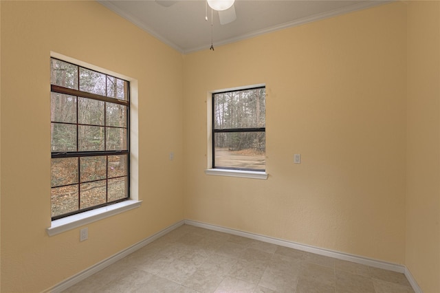 spare room featuring baseboards, ornamental molding, a ceiling fan, and a healthy amount of sunlight