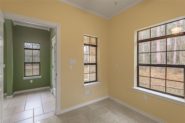 unfurnished room with a wealth of natural light, baseboards, and crown molding