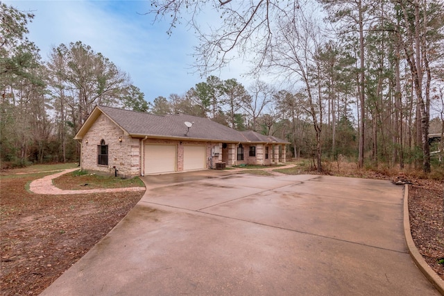 ranch-style house featuring a garage, stone siding, driveway, and roof with shingles