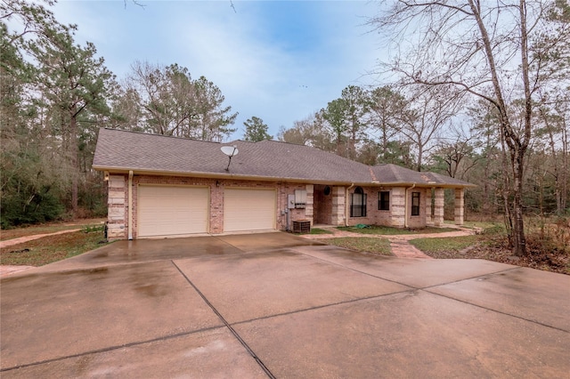 view of front of property with an attached garage, a shingled roof, concrete driveway, and brick siding