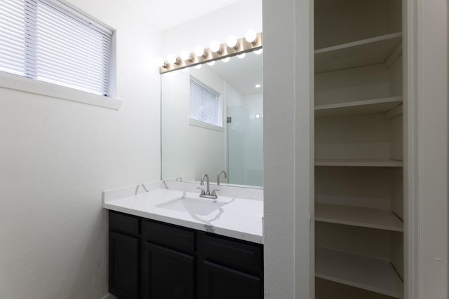 bathroom featuring a spacious closet, an enclosed shower, and vanity