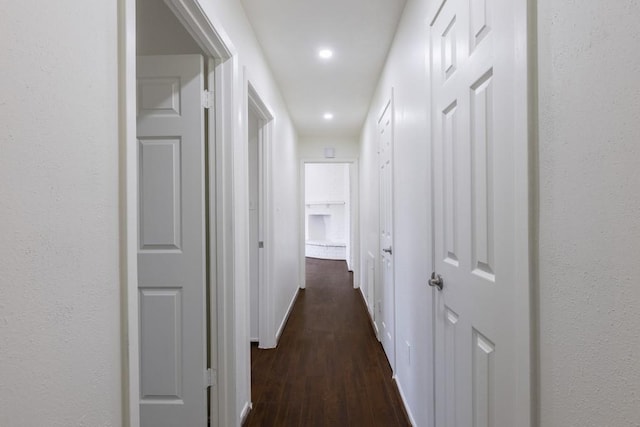 hall with baseboards, dark wood-style flooring, and recessed lighting