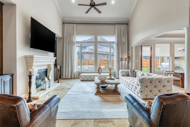 living room featuring crown molding, ceiling fan, and ornate columns