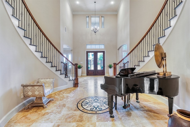 foyer entrance featuring ornamental molding, a notable chandelier, and french doors