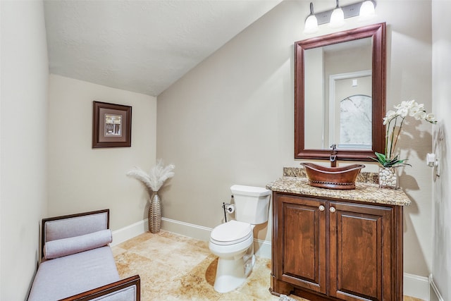 bathroom with vanity, toilet, tile patterned flooring, and a textured ceiling