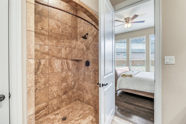 bathroom with ceiling fan, wood-type flooring, and a tile shower