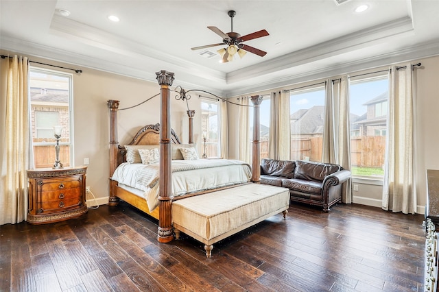 bedroom featuring crown molding, a tray ceiling, dark wood-type flooring, and ceiling fan