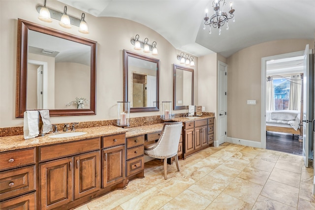 bathroom with an inviting chandelier, lofted ceiling, and vanity