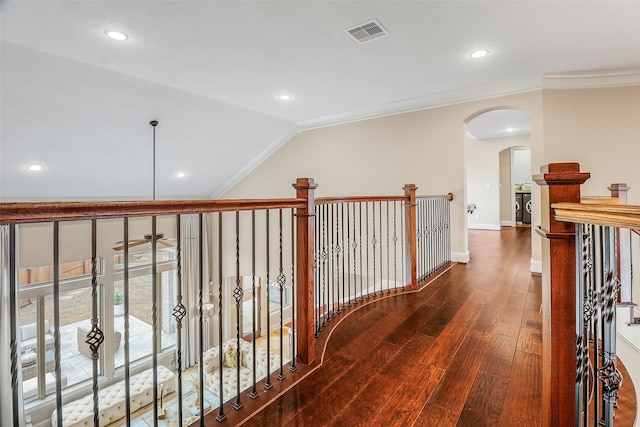 corridor featuring ornamental molding, dark hardwood / wood-style flooring, and vaulted ceiling