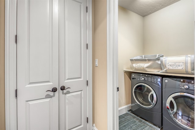 washroom featuring washing machine and dryer and a textured ceiling