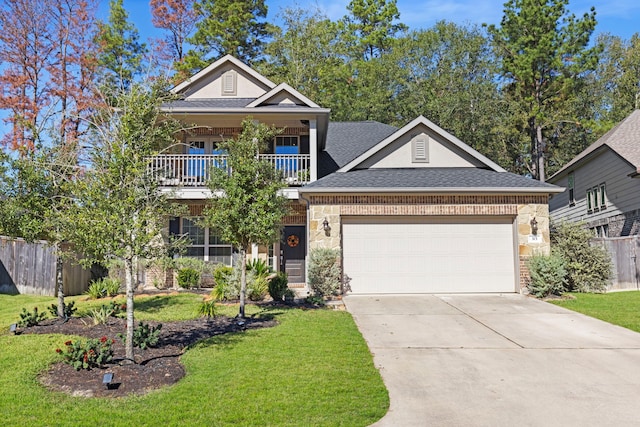 view of front of property featuring a garage, a front yard, and a balcony