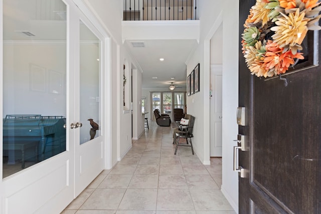 tiled foyer entrance featuring crown molding and french doors