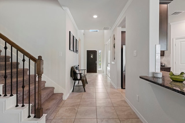 tiled entrance foyer featuring ornamental molding