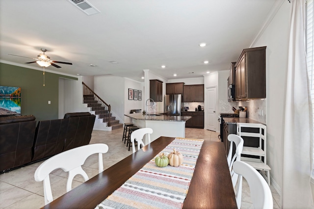 tiled dining room featuring crown molding, sink, and ceiling fan