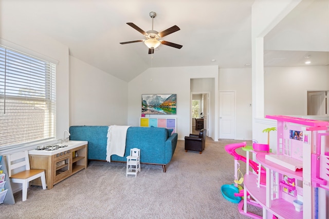 playroom with ceiling fan, vaulted ceiling, and light carpet