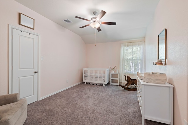 carpeted bedroom with a nursery area, ceiling fan, and vaulted ceiling