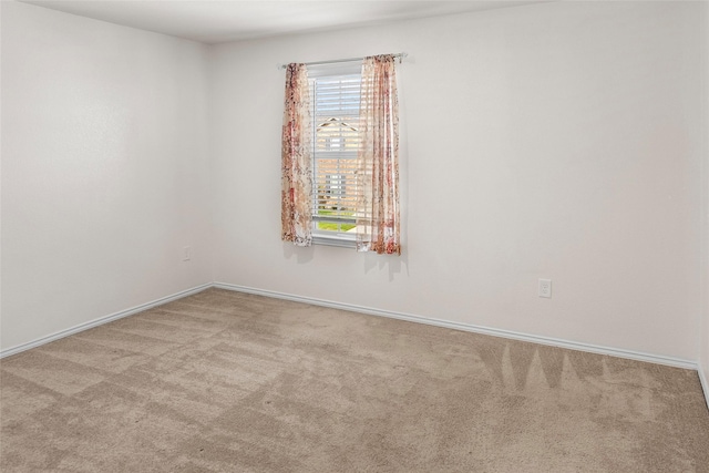 spare room featuring light carpet