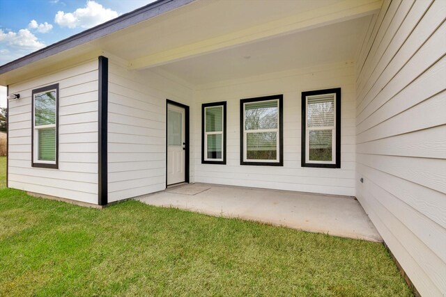 113 County Road 645, Kenefick, TX 77535 - doorway to property featuring a lawn and a patio