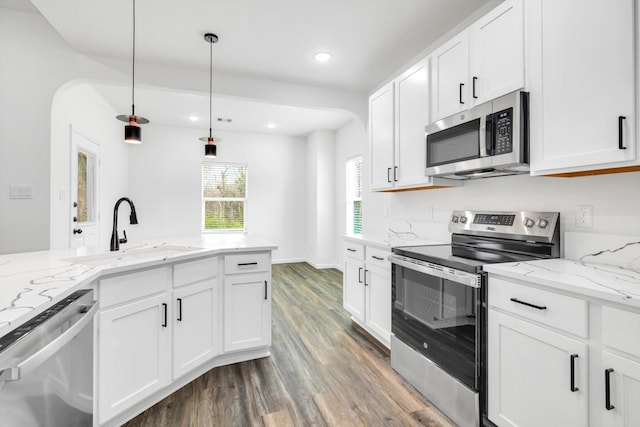 113 County Road 645, Kenefick, TX 77535 - kitchen with white cabinetry, hanging light fixtures, sink, and appliances with stainless steel finishes