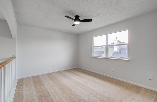 unfurnished room with ceiling fan, a textured ceiling, and carpet flooring