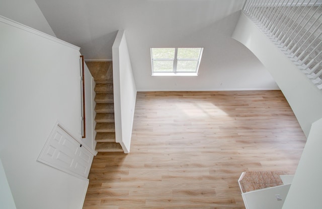 stairs with lofted ceiling and hardwood / wood-style floors