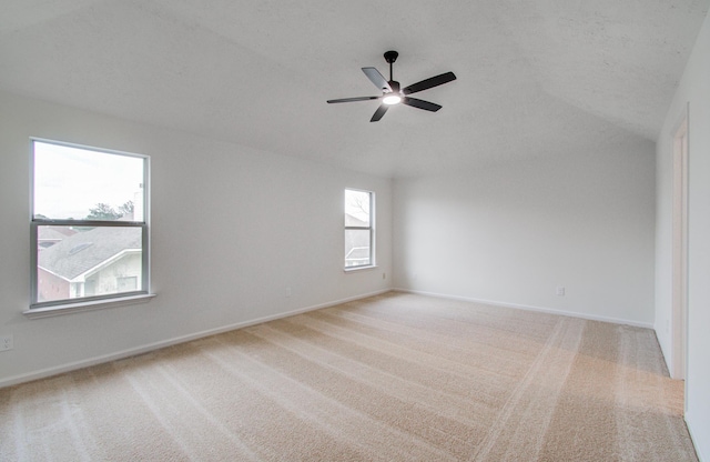 carpeted empty room featuring lofted ceiling, a textured ceiling, and ceiling fan