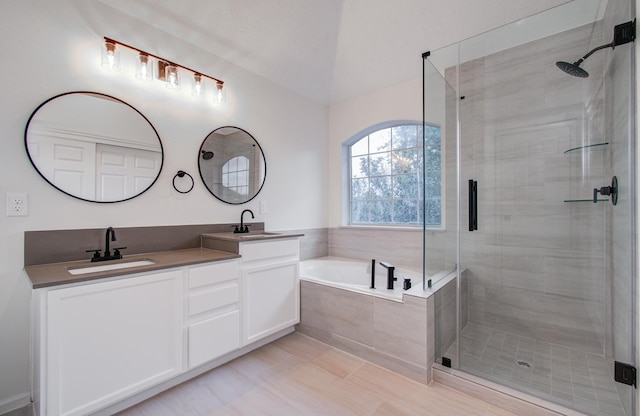 bathroom with vanity and shower with separate bathtub