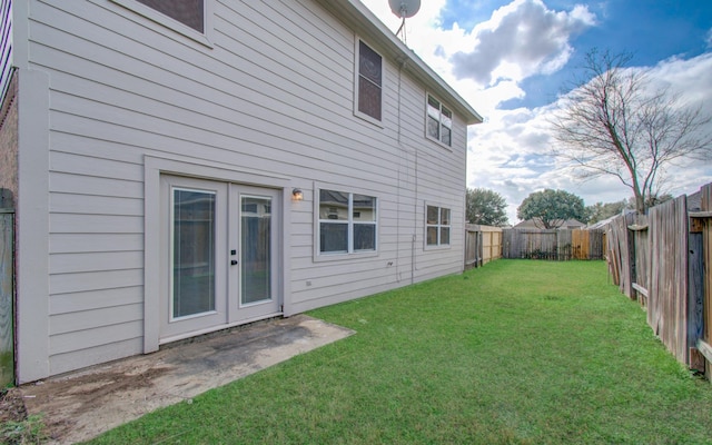 rear view of house featuring a lawn and french doors