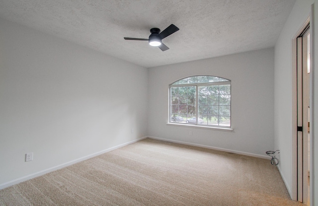 unfurnished room featuring light colored carpet, a textured ceiling, and ceiling fan