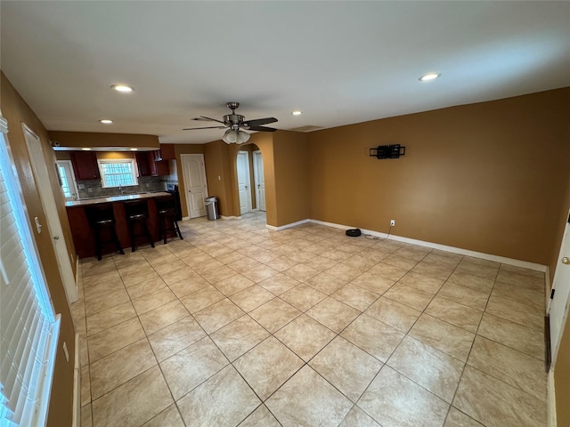 unfurnished living room featuring light tile patterned floors and ceiling fan