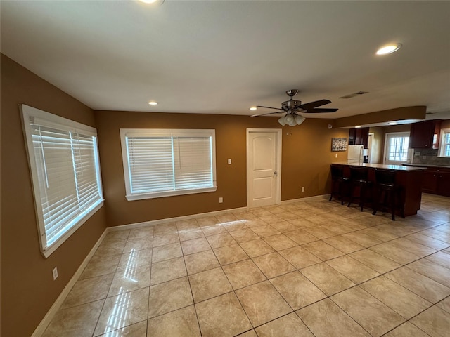 unfurnished living room with light tile patterned floors and ceiling fan