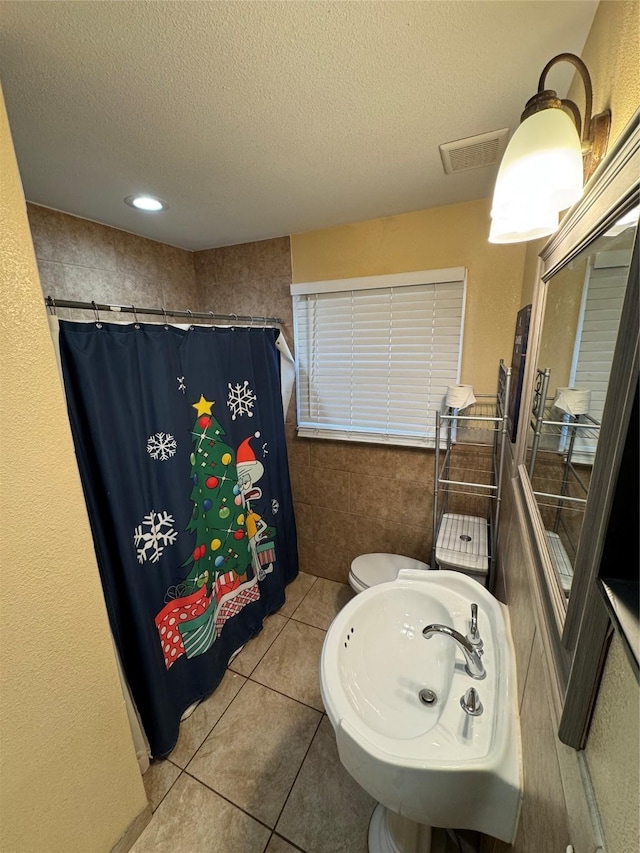 bathroom featuring sink, tile patterned flooring, a textured ceiling, a shower with curtain, and toilet