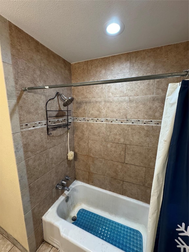 bathroom featuring a textured ceiling and shower / bath combo with shower curtain