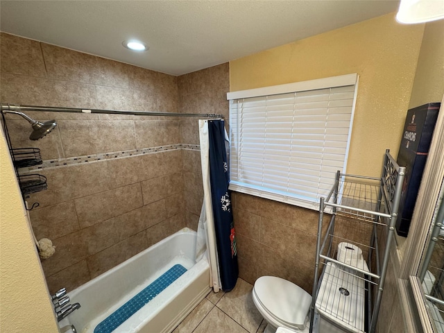 bathroom with tile patterned floors, toilet, shower / tub combo, and tile walls