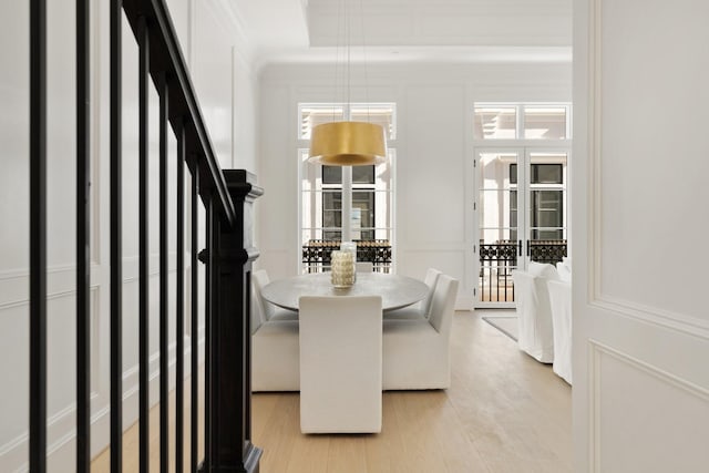 dining room featuring crown molding and light hardwood / wood-style flooring